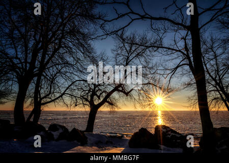 Lever du soleil d'hiver le long de la côte rocheuse couverte de neige du lac Érié, dans le nord-ouest de l'Ohio. Banque D'Images