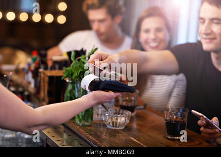 Groupe d'Amis de payer pour repas au restaurant Banque D'Images