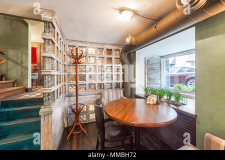 Moscou - AOÛT 2014 : l'intérieur du restaurant de cuisine maison PANAEHALI «' dans un style loft. Un endroit séparé à la table ronde près de la fenêtre Banque D'Images