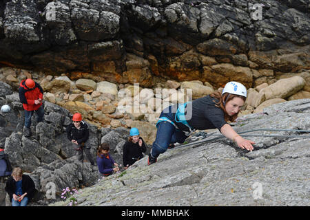 Escalade club d'escalade et la descente en rappel sur les falaises à côté de la mer. Une variété de participants jeunes et vieux Banque D'Images