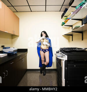 Une femme de race blanche super héros bureau prend une pause et a snack. Banque D'Images