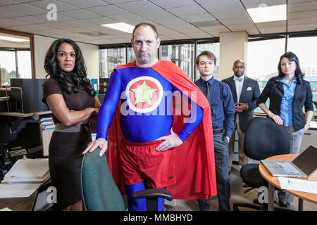 Caucasian middle aged man super héros et sa race mixte de l'équipe du bureau en thieir Banque D'Images