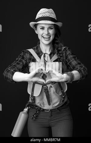 La recherche de lieux d'inspiration. smiling young woman voyageur avec sac à dos en forme de cœur montrant isolé sur les mains Banque D'Images