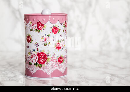 Conteneur de stockage d'étain coloré avec motif floral sur fond blanc Banque D'Images