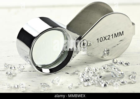 Diamants taille brillant avec loupe pliante sur fond de bois Banque D'Images