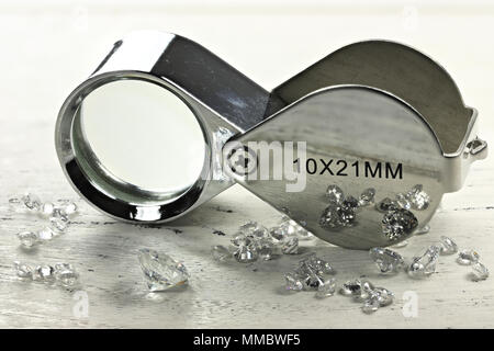 Diamants taille brillant avec loupe pliante sur fond de bois Banque D'Images