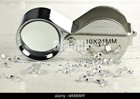 Diamants taille brillant avec loupe pliante sur fond de bois Banque D'Images