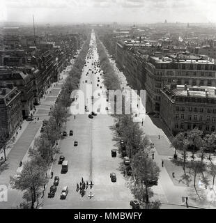 Années 1950, historique. Vue de dessus vers le bas le large boulevard bordé d'arbres, l'Avenue des Champs-Elysées, Paris, France, l'un des plus grand et belles avenues dans le monde, près de 2 kilomètres de longueur, et qui relie l'Arc de Triomphe à la place de la Concorde. Banque D'Images