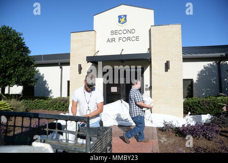 Jeremy Railey, Vectrus Boutique Structure Carpenter, et TJ Wendt, Vectrus structures Structures Shop conduire, faire des sacs à mettre autour de l'extérieur du deuxième bâtiment de l'Armée de l'air le 6 octobre 2017, sur la base aérienne de Keesler, Mississippi. Sacs de sable ont été placés autour de bâtiments clés sur la base aérienne Keesler pour aider à prévenir les inondations en vue de la tempête tropicale Nate. (U.S. Air Force photo par un membre de la 1re classe Suzanna Plotnikov) Banque D'Images