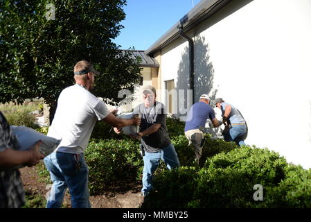 Vectrus entrepreneurs Boutique Structures place des sacs de sable autour du deuxième bâtiment de l'Armée de l'air le 6 octobre 2017, sur la base aérienne de Keesler, Mississippi. Sacs de sable ont été placés autour de bâtiments clés sur la base aérienne Keesler pour aider à prévenir les inondations en vue de la tempête tropicale Nate. (U.S. Air Force photo par un membre de la 1re classe Suzanna Plotnikov) Banque D'Images