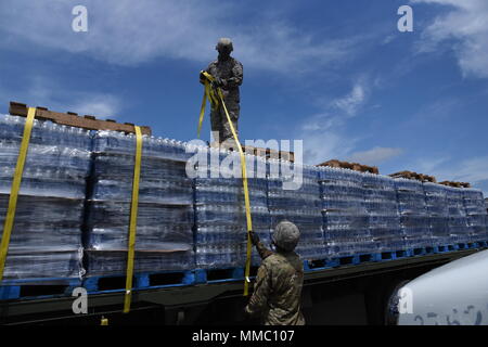 Des soldats de la réserve de l'armée américaine de la CPS. Jeffrey Lebron et le Sgt. Sergio Alvarado, affecté à la 432e compagnie de transport dans la région de Ceiba, communication, sûr de l'eau que les palettes ont été transportés à el Departamento de la Vivienda à San Juan, 7 octobre. Banque D'Images