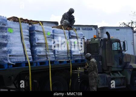 Des soldats de la réserve de l'armée américaine de la CPS. Jeffrey Lebron et le Sgt. Sergio Alvarado, affecté à la 432e compagnie de transport dans la région de Ceiba, communication, sûr de l'eau que les palettes ont été transportés à el Departamento de la Vivienda à San Juan, 7 octobre. Banque D'Images