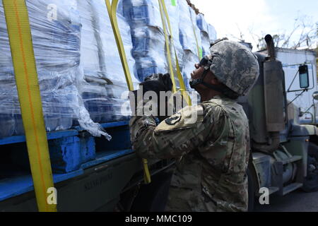 Des soldats de la réserve de l'armée américaine de la CPS. Jeffrey Lebron et le Sgt. Sergio Alvarado, affecté à la 432e compagnie de transport dans la région de Ceiba, communication, sûr de l'eau que les palettes ont été transportés à el Departamento de la Vivienda à San Juan, 7 octobre. Banque D'Images