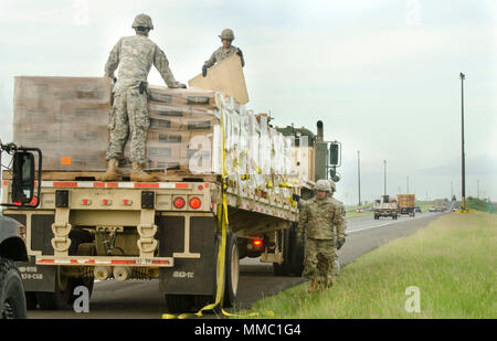 Des soldats de la réserve de l'Armée américaine affecté à la 432e compagnie de transport, 346e, 166e bataillon de transport Groupe de soutien régional, 1ère Commande de soutien de mission, hors de Ceiba, Puerto Rico, fixer des sangles d'arrimage au cours d'une mission de livraison de nourriture à la périphérie de San Juan, Porto Rico, le 6 octobre 2017. America's Army Reserve est ici de fournir des capacités vitales de l'organisme fédéral à l'appui du ministère de la Défense, ministère de l'armée, de l'état et les autorités locales en cas de catastrophes naturelles et causées par l'homme. (U.S. Réserve de l'armée photo par le Sgt. Carlos Garcia) Banque D'Images