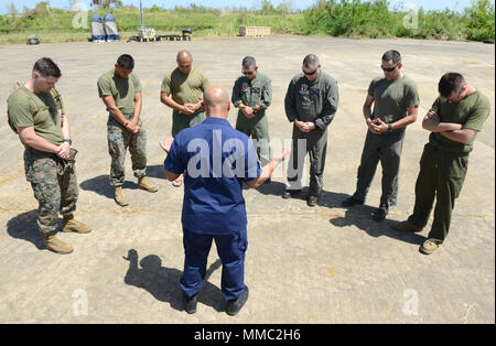 Le lieutenant de la Garde côtière des États-Unis Francisco Muniz Valle, aumônier de la Garde côtière canadienne Air Station Borinquen, Puerto Rico, fournit des services religieux aux Marines américains affectés à l'Escadron 264 Tiltroter moyen maritime à Rafael Hernandez Airport à Aguadilla, Puerto Rico, 8 octobre 2017. Muniz Valle a fourni des services religieux et le conseil aux Marines et les marins de VMM-264, déployée à Porto Rico pour l'Ouragan Maria l'intervention et au rétablissement de leur domicile au Marine Corps Air Station New River, N.C. Photo de la Garde côtière des États-Unis par le maître de Kyle Niemi Banque D'Images