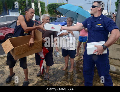 Le lieutenant JG. Lucas Taylor, un pilote de la Garde côtière à Air Station Borinquen, Puerto Rico, fournit de la nourriture à un résident de Moca, Porto Rico, le 9 octobre 2017. La Garde côtière et les organismes partenaires ont été la prestation de l'Agence fédérale de gestion des urgences des fournitures à Porto Rico dans l'ensemble de personnes qui ont été touchées par l'Ouragan Maria. U.S. Coast Guard photo de Maître de 3e classe David Micallef Banque D'Images