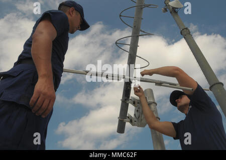 Les gardes-côtes américains Maître de 1re classe Michael Hazzard et maître de 1re classe Christopher Shelton, techniciens en électronique avec la Garde côtière des États-Unis Le Secteur de San Juan, réparer le matériel de communication sur le toit de l'édifice du centre de communications à San Juan, Porto Rico, le 11 octobre 2017. Les gardes côte maintenu l'équipement en prévision de la réouverture du centre de commandement de la Garde côtière des États-Unis dans le secteur de San Juan. (U.S. Photo de l'armée par la CPS. Gabrielle Weaver) Banque D'Images