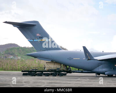 Aviateurs du 821e groupe d'intervention d'urgence travailler avec des aviateurs du 198th Airlift Squadron, 3e Escadron de transport aérien, 436e Escadron de soutien des opérations et le 736e Escadron de maintenance des aéronefs, tous nos de Dover Air Force Base, Texas, engins de déchargement pour être utilisé par du personnel militaire à l'appui des efforts de secours à l'Ouragan Maria Jose Aponte de la Torre Airport de Ceiba, Puerto Rico, 11 octobre 2017. Aéronef à voilure fixe comme ce C-17 Globemaster III ont été utilisés tout au long de l'effort de secours à apporter dans la plupart des matières premières, des fournitures et du personnel en Puerto Rico. (U.S. Air forc Banque D'Images