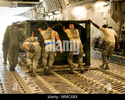 Aviateurs du 821e groupe d'intervention d'urgence travailler avec des aviateurs du 198th Airlift Squadron, 3e Escadron de transport aérien, 436e Escadron de soutien des opérations et le 736e Escadron de maintenance des aéronefs, tous nos de Dover Air Force Base, Texas, engins de déchargement pour être utilisé par du personnel militaire à l'appui des efforts de secours à l'Ouragan Maria Jose Aponte de la Torre Airport de Ceiba, Puerto Rico, 11 octobre 2017. Aéronef à voilure fixe comme ce C-17 Globemaster III ont été utilisés tout au long de l'effort de secours à apporter dans la plupart des matières premières, des fournitures et du personnel en Puerto Rico. (U.S. Air forc Banque D'Images