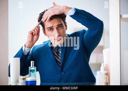 L'homme est en train de s'habiller pour aller au travail, dans la salle de bains Banque D'Images