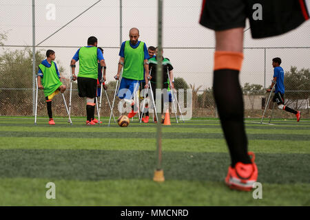 La bande de Gaza. 10 mai, 2018. Les joueurs de soccer amputés palestiniens prennent part à une session de formation de leur équipe au stade de la municipalité de Deir el Balah, dans le centre de la bande de Gaza, le 10 mai 2018. Pour la première fois dans le peuple palestinien de Gaza, une équipe de football des amputés de sexe masculin a été formée récemment, pour jeter les bases d'un tel sport dans le territoire d'un blocus israélien. L'équipe de 12 joueurs, nommé "Le héros", pourrait être une lueur d'espoir pour de nombreux jeunes avec amputations causées par de fréquents cycles de violence avec Israël et d'autres accidents. Credit : Stringer/Xinhua/Alamy Live News Banque D'Images