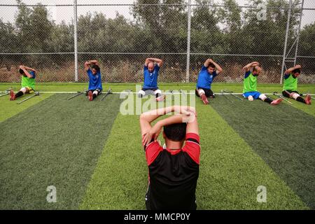 La bande de Gaza. 10 mai, 2018. Les joueurs de soccer amputés palestiniens prennent part à une session de formation de leur équipe au stade de la municipalité de Deir el Balah, dans le centre de la bande de Gaza, le 10 mai 2018. Pour la première fois dans le peuple palestinien de Gaza, une équipe de football des amputés de sexe masculin a été formée récemment, pour jeter les bases d'un tel sport dans le territoire d'un blocus israélien. L'équipe de 12 joueurs, nommé "Le héros", pourrait être une lueur d'espoir pour de nombreux jeunes avec amputations causées par de fréquents cycles de violence avec Israël et d'autres accidents. Credit : Stringer/Xinhua/Alamy Live News Banque D'Images