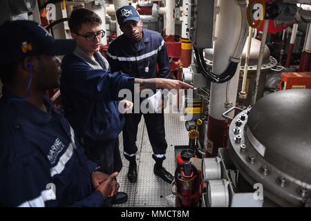 171012-N-FP878-039 OCÉAN ATLANTIQUE (oct. 12, 2017) 3ème classe 4400 Machiniste James Dyer, de Scott City, Kansas, centre, donne aux marins camerounais Ensign Tchinde Etienne et le lieutenant J.G. Jean Mendoua un tour de génie sont à bord de la classe Arleigh Burke destroyer lance-missiles USS Donald Cook (DDG 75), 12 octobre, 2017. Donald Cook, l'avant-déployé à Rota, en Espagne, est sur sa sixième patrouille dans la sixième flotte américaine zone d'opérations à l'appui des alliés et partenaires, et les intérêts de sécurité nationale des États-Unis en Europe. (U.S. Photo par marine Spécialiste de la communication de masse 1re classe Theron J. Godb Banque D'Images