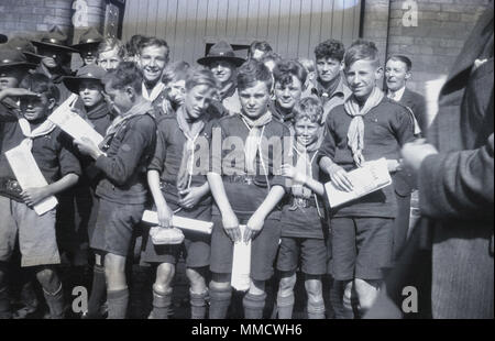 années 1930, un grand groupe de scouts enthousiastes, avec des certificats, rassemblés à l'extérieur. De différents âges, les plus âgés portant des chapeaux, les scouts viennent de rentrer en masse d'un voyage à l'étranger en Irlande. Banque D'Images