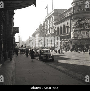 1954, historique, une vue sur Lower Regent Street depuis Piccadilly Circus, Westminster, Londres, Angleterre. Le cinéma Plaza (théâtre) est sur la droite. Construit pour Paramount Pictures en 1926, le Plaza était un bâtiment somptueux avec 1800 places assises et une petite scène. A annoncé sur son extérieur quelques-uns des plus grands noms du monde du cinéma, Humphrey Bogart, Audrey Hepburn et William Holden, qui ont été les vedette dans le film de comédie-drame 'Sabrina Fair', réalisé par Billy Wilder. Le film américain était une production Paramount Banque D'Images