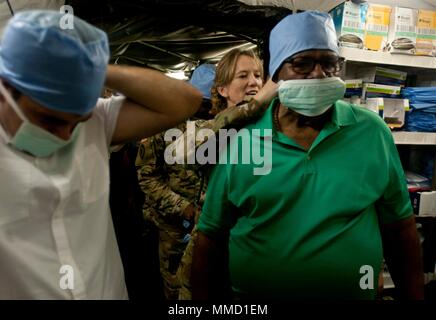 Le colonel Rachele Smith, commandant de la 14e Hôpital de soutien au combat, 44e brigade médicale de Fort Benning, Géorgie, aide Humacao Maire Marcelo Trujillo avec un masque chirurgical sur une visite de leur hôpital à Humacao Arena à Humacao, Puerto Rico, 13 octobre 2017. La 14e CSH a pour mission de fournir un soutien et des soins aux patients de sauvetage aux citoyens dans la région du Sud-Est de l'île. Banque D'Images