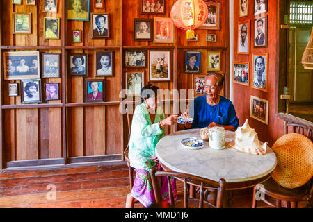 Krabi, Thaïlande - Mai 3, 2015 : senior woman boire le thé ensemble à la table de marbre blanc dans la maison traditionnelle en bois où le mur déco Banque D'Images