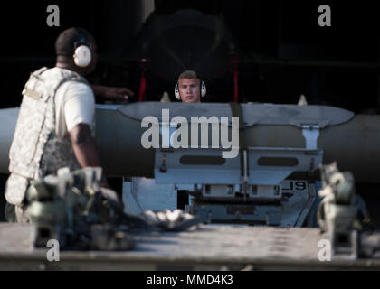 Le sergent de l'US Air Force. Marcus Knight des signaux à un membre de la 1re classe Joshua Cartlidge, 8e Escadron de maintenance (Air) de la charge d'armes de l'équipage, tout en effectuant une GBU-31 Joint Direct Attack Munition recharger dans un abri d'aéronefs au cours de l'effort Beverly Pack 18-1 à Kunsan Air Base, République de Corée, le 10 octobre 2017. L'essai d'aviateurs sur leur capacité à générer de grandes quantités de munitions diverses pour que les aéronefs prêtes au combat en faveur de la simulation d'un commandement de la composante aérienne de l'ordre de mission aérienne basé sur des scénarios réels. (U.S. Photo de l'Armée de l'air par le sergent. Victoria H. T Banque D'Images