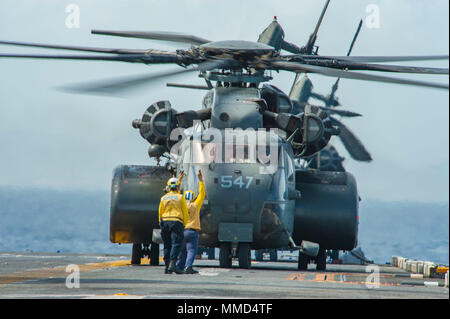 171017-N-JW440-1111 MER DES CARAÏBES (oct. 17, 2017) le signal des marins d'un décollage MH-53E Sea Dragon hélicoptère affecté à l 'avant-garde' de la lutte contre les mines d'Hélicoptère 14 Escadron (HM-14) à partir de l'assaut amphibie USS Wasp LHD (1). Le Wasp est d'aider aux secours à Puerto Rico à la suite du cyclone Maria. Le ministère de la défense soutient la Federal Emergency Management Agency (FEMA), le principal organisme fédéral, en aidant les personnes touchées par l'Ouragan Maria afin de minimiser la souffrance et est une composante de l'ensemble de l'intervention. (U.S. Marine p Banque D'Images