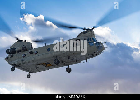 Un groupe de travail de l'armée américaine sont tumultueuses CH-47F Chinook se prépare à la terre lors d'un exercice d'entraînement avec un ange gardien équipe chargée du 83e Escadron de sauvetage expéditionnaire de Bagram Airfield, Afghanistan, le 14 mars 2018. Les équipages de l'armée et la Force aérienne ange gardien les équipes ont mené l'exercice de construire le travail d'équipe et les procédures qu'ils fournissent la capacité de récupération du personnel mixte, contribuant à l'acheminement de l'airpower décisif pour le Commandement central américain. (U.S. Air Force Banque D'Images