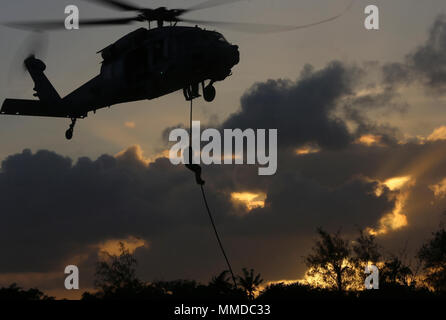 Les Marines américains avec vigueur l'entreprise de reconnaissance, 3e Bataillon de Reconnaissance, 3e Division de marines, III Marine Expeditionary Force ; British Royal Marines avec J Company, 42 marins et commandos avec des explosifs et de l'unité mobile 5 conduite d'insertion et de formation spéciale des raids avec une section de MH-60SS à partir d'hélicoptères de combat sur mer 25 Mars 19, 2018, sur Guam. Les unités sont combinées, conjointes de formation afin d'élaborer en commun des procédures dans une visite, un conseil, une perquisition et saisie de l'environnement pour qu'elles offrent une plus grande souplesse et capacité de prêt à la mission c géographique Banque D'Images