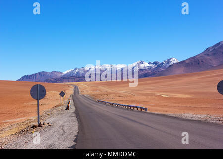 Une longue route à travers le désert d'Atacama, au Chili. Paysage de sable et de rochers à haute altitude en début de matinée. Banque D'Images