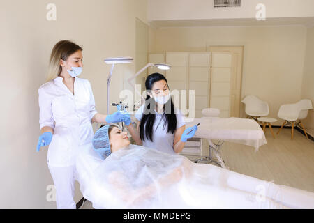 Maquillage permanent pour faire Cosmetologist femme au cabinet avec une infirmière. Banque D'Images