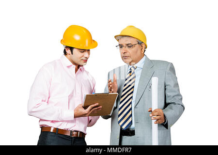 Deux architectes masculins avec le plan directeur et le presse-papiers working at Construction site - Banque D'Images