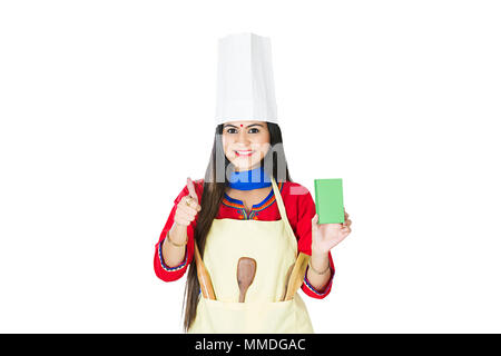 Une femme reste au foyer porter un tablier et des Chef-Hat showing Thumbs-up avec fort Banque D'Images