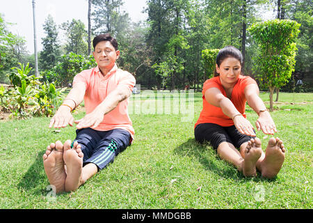 Deux couple fitness stretching faire exercices du matin à l'intérieur du parc, Banque D'Images