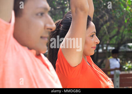 Deux exercices de fitness Couple Doing Yoga Surya-Namaskar ensemble Parc d'entraînement Banque D'Images