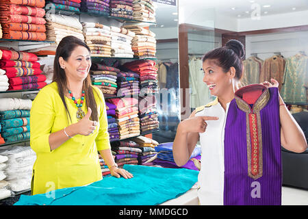 Deux femmes commerçant vendant Kurti Shopping Clothes In-Shop achat du client Banque D'Images