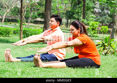 Deux Couple Stretching Yoga pratique herbe matin Entraînement Exercice In-Park Banque D'Images