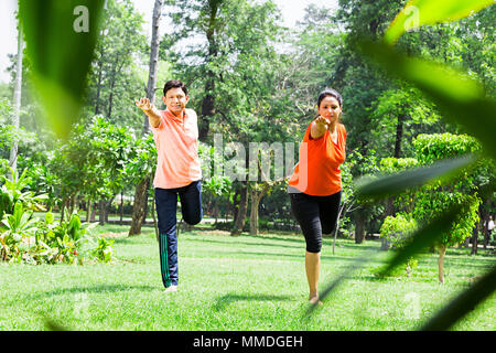 Deux Couple Doing Yoga Dhanurasana Dandayamana Stretching Fitness Jardin Banque D'Images