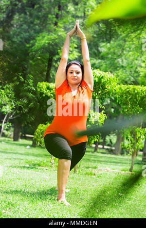 Une femme faisant du yoga Méditation Surya-Namaskar étirement exercice fitness Jardin Banque D'Images