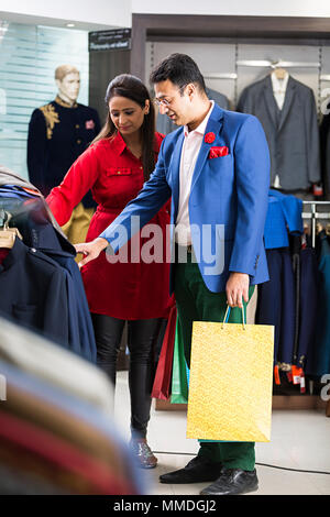 Deux adultes choix Sélection de fonction de vérifier les boutiques de vêtements Shop In-Mall Banque D'Images