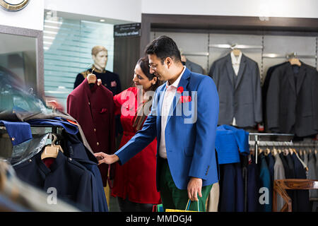 Couple marié choix Sélection Chèques shopping manteau-In-Clothes Détail Showroom Banque D'Images