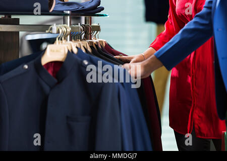 Couple marié choix Sélection Coat vérifie votre In-Clothes Retail Shop Banque D'Images