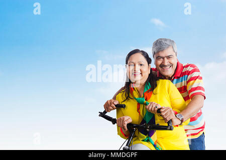 Deux vieux amants Smiling Couple riding a Bicycle Profitez d In-Outdoors Banque D'Images