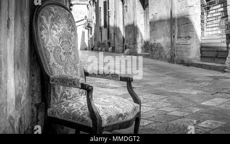 La ville de Lecce, Italie. Vintage chaise avec rue de la vieille ville en arrière-plan. Banque D'Images